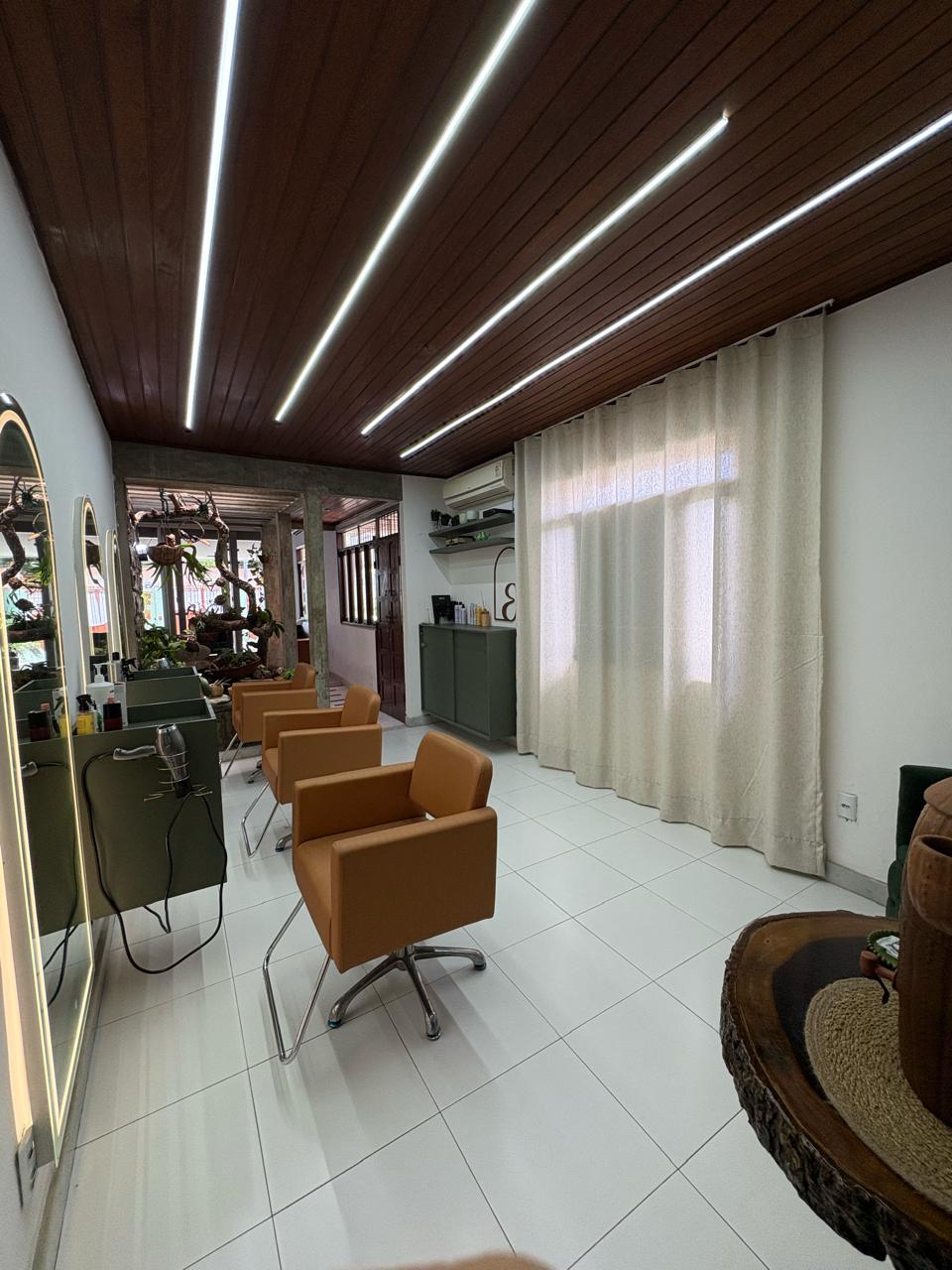 Interior do salão com estações de trabalho e design moderno.