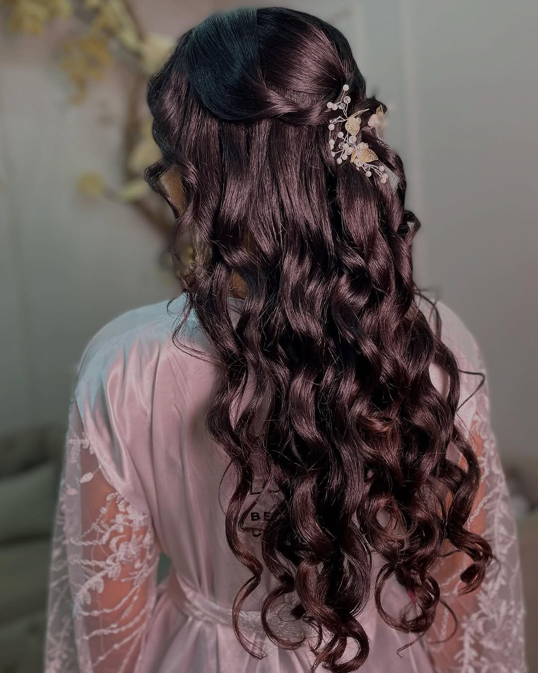 Penteado debutante com cachos longos e acessório floral delicado