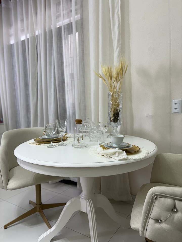 Mesa decorada com taças de cristal, louças finas e arranjo de trigo seco